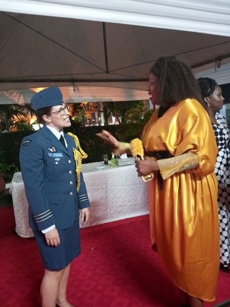 A woman in a gold dress speaking with an officer in uniform