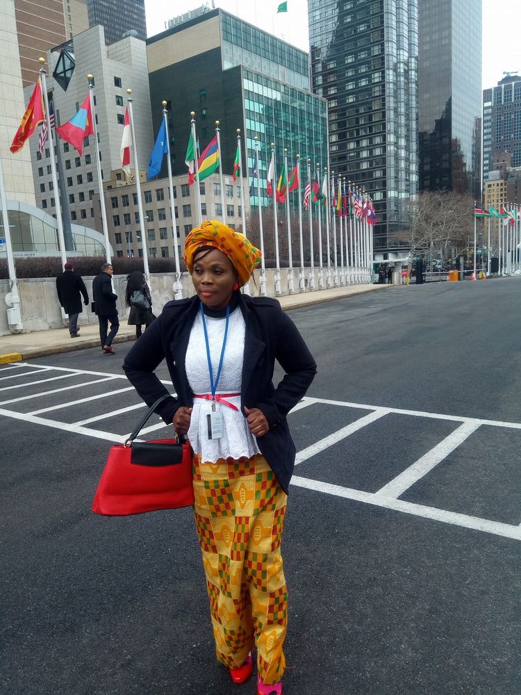 A woman on a city street near a row of international flags