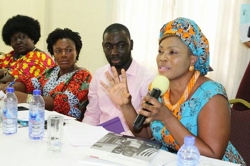 A woman speaking into a microphone at a meeting